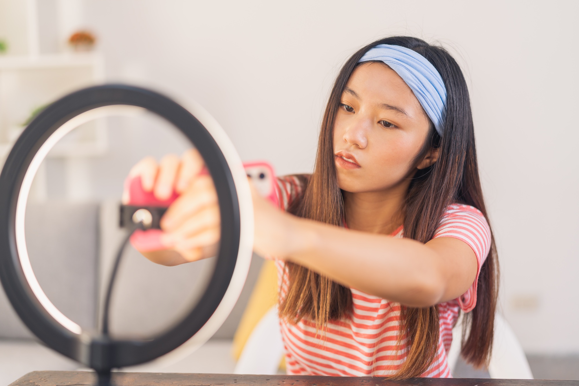 Asian female influencer, fixing the tripod