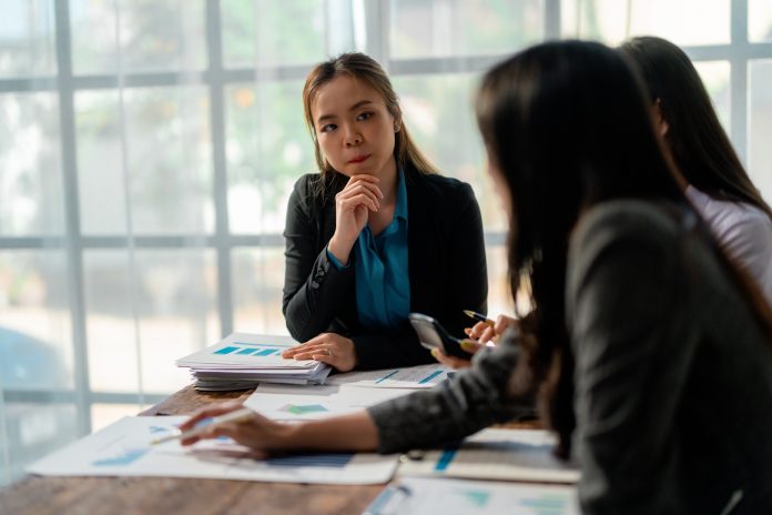 Businesswomen discussing marketing strategy during meeting in modern office