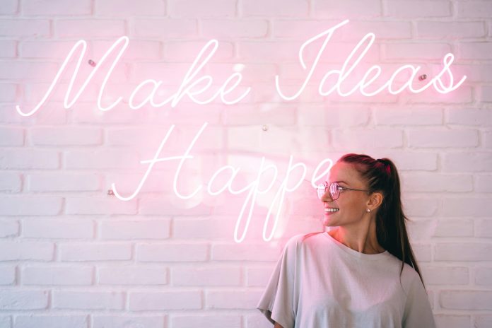 Cheerful teenager near font neon message