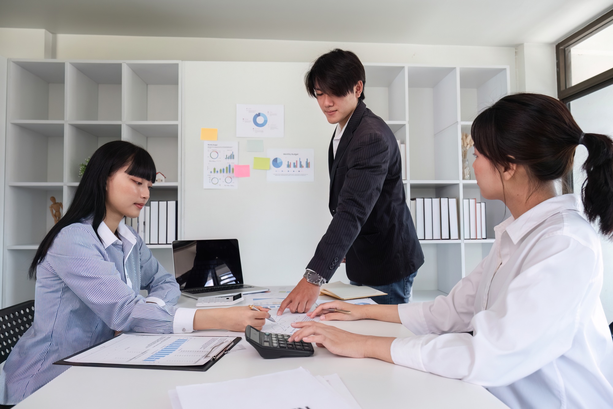 Young Business Team Collaborating on Marketing Strategy in Modern Office Setting with Charts and